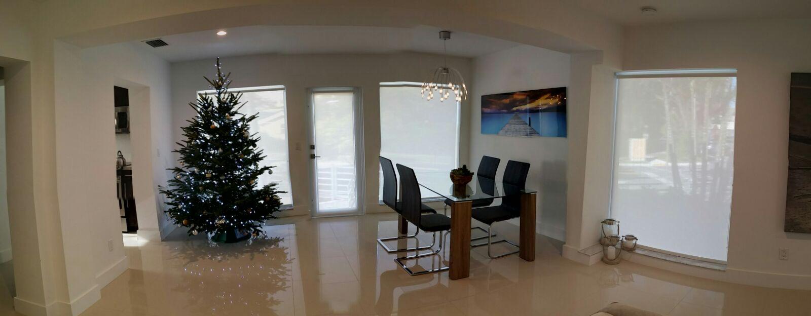 Solar screen roller shades throughout an open living and dining space