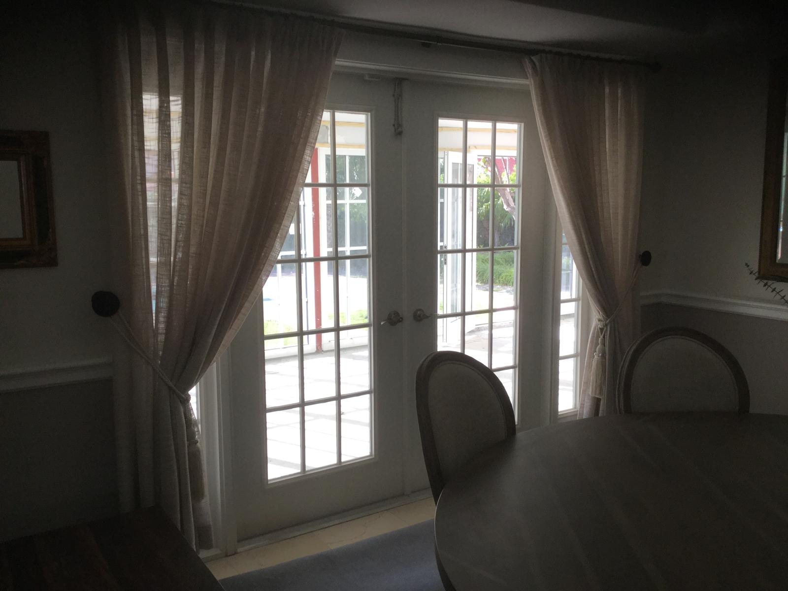 Sheer curtains tied back beside French doors