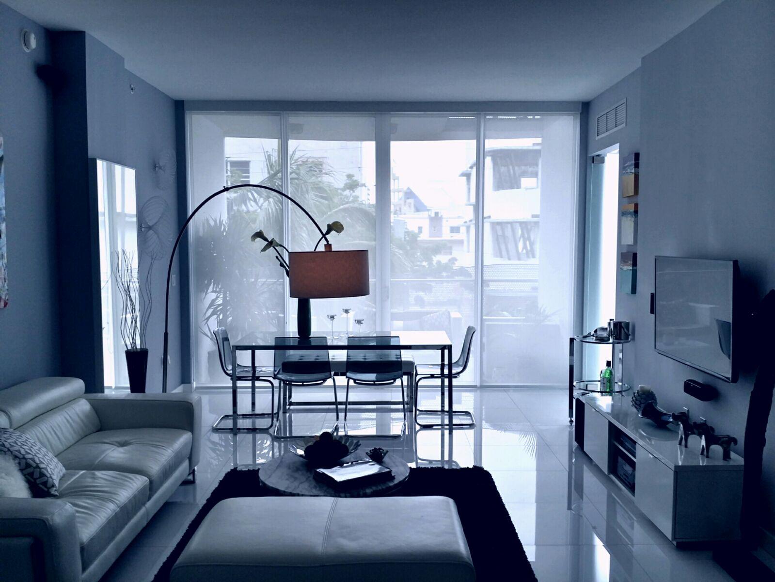 Living and dining space with full-height solar screen shades