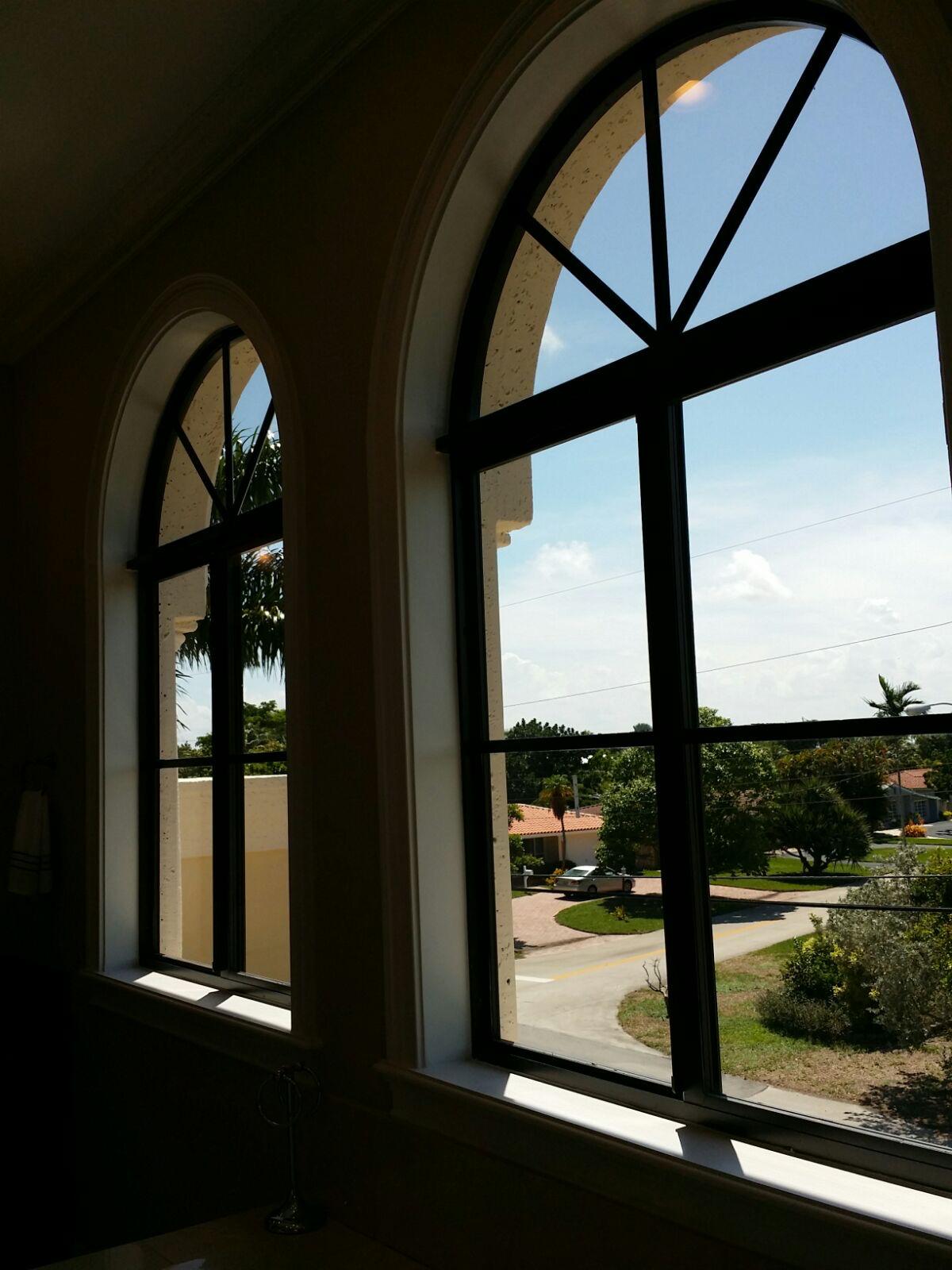 Uncovered arched bathroom windows with dark frames