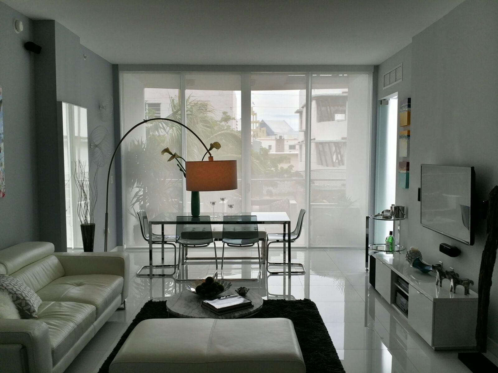 Living room roller shades filtering daylight across large windows